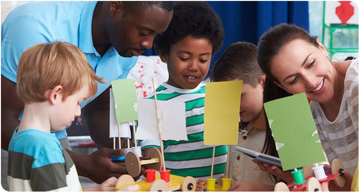 Teachers and children working on a science project